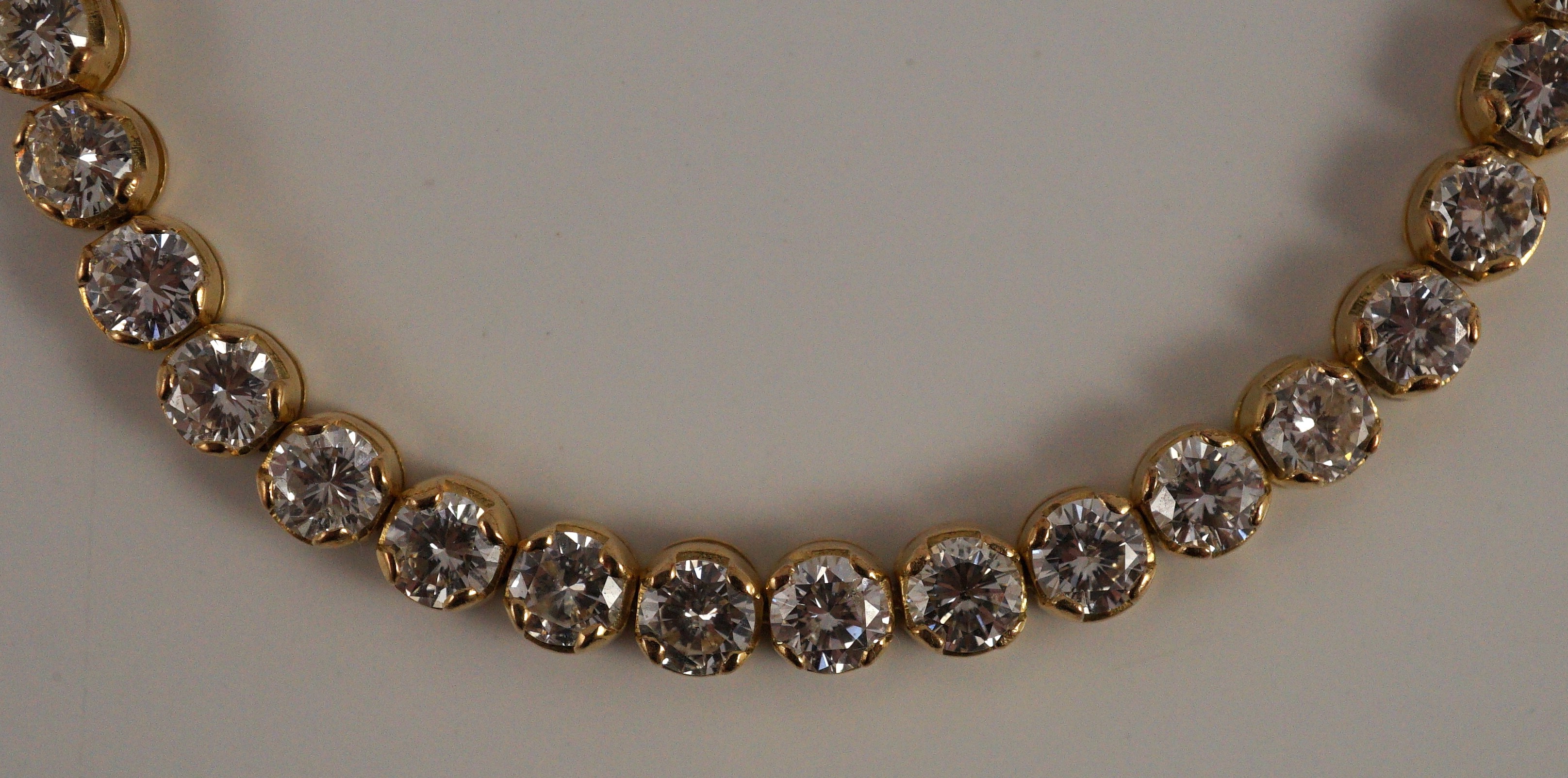 A modern 18k gold and round brilliant cut diamond set line bracelet